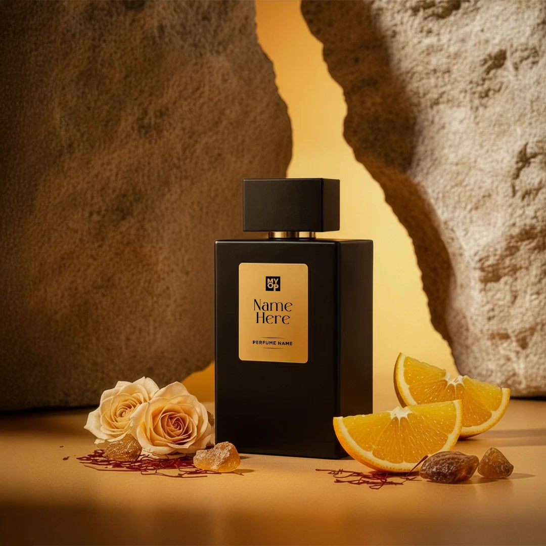 Black perfume bottle with a label on a textured surface with flowers and oranges.